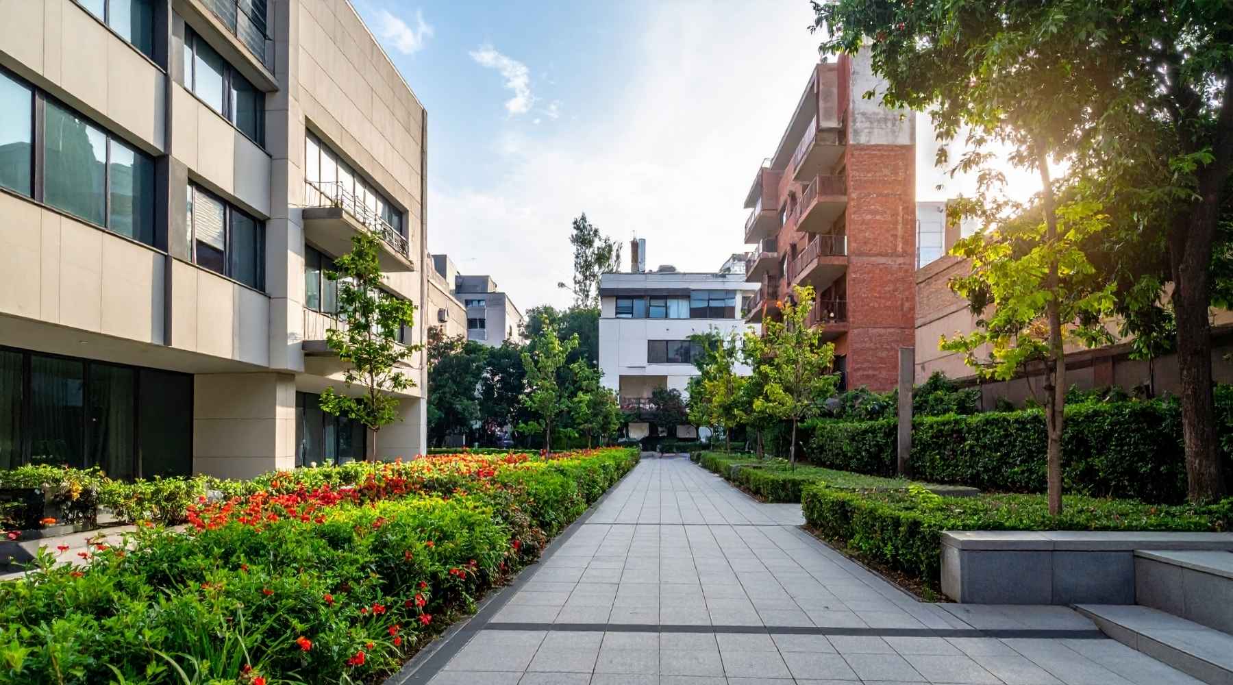 Moderne Wohnanlage mit großzügigem Garten – stilvolle Architektur und gepflegte Grünflächen bieten eine hohe Lebensqualität. Einladender Weg durch die Gartenanlage zwischen eleganten Gebäuden, perfekt für urbane Bewohner, die Natur und Komfort suchen.